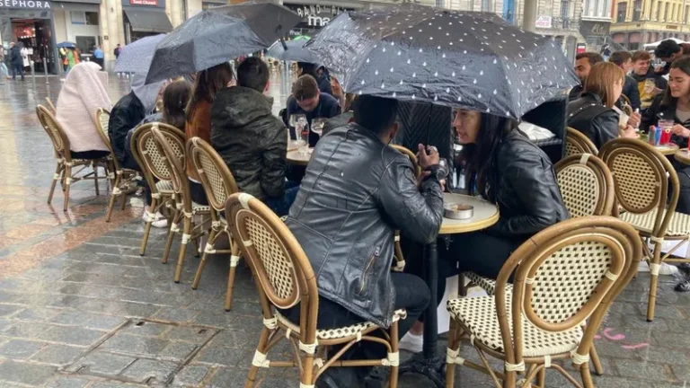 personnes profitant dun cafe sous la pluie