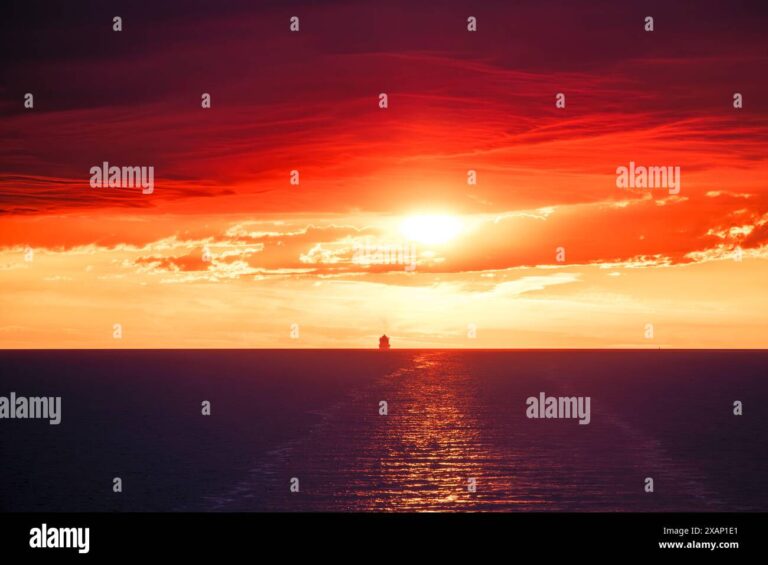 un cargo naviguant vers marseille au coucher du soleil