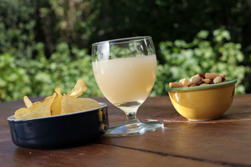 un verre de pastis sur une table en terrasse